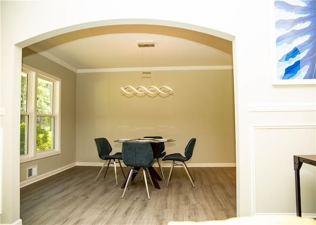 dining area with crown molding and wood-type flooring