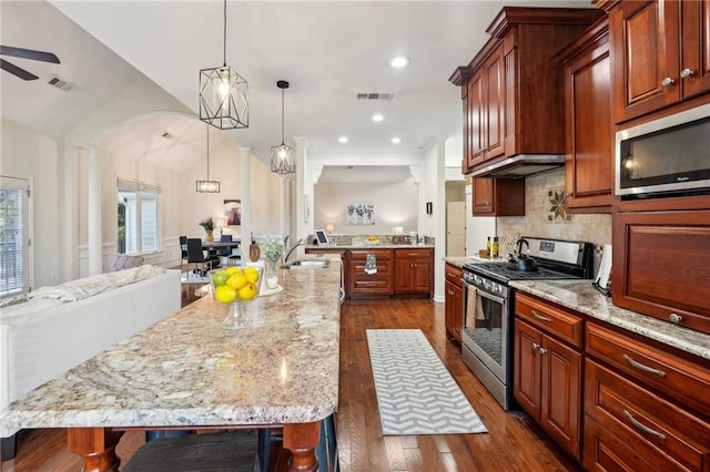 kitchen featuring visible vents, a sink, vaulted ceiling, appliances with stainless steel finishes, and dark wood-style flooring