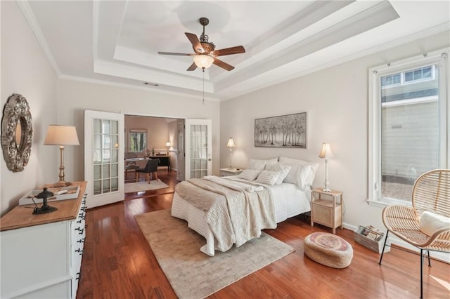 bedroom with multiple windows, french doors, a raised ceiling, and dark wood-style flooring