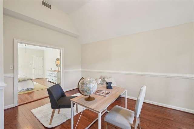 office area featuring visible vents, lofted ceiling, baseboards, and hardwood / wood-style flooring