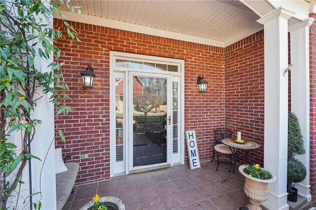 view of exterior entry featuring brick siding