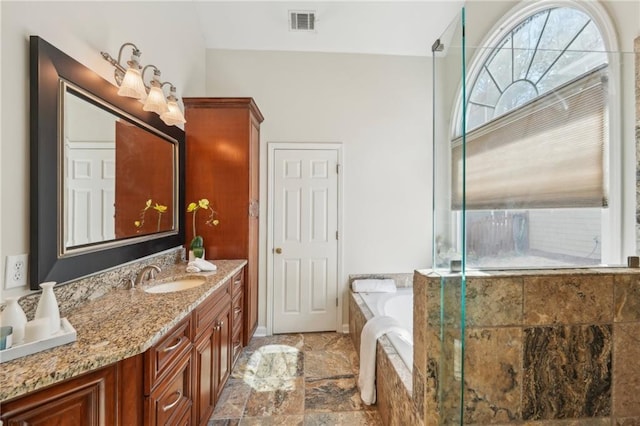 full bath featuring vanity, visible vents, stone finish flooring, walk in shower, and a garden tub