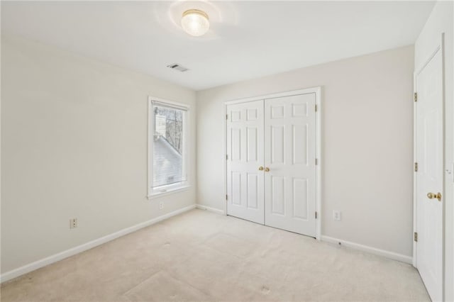 unfurnished bedroom featuring carpet flooring, visible vents, baseboards, and a closet