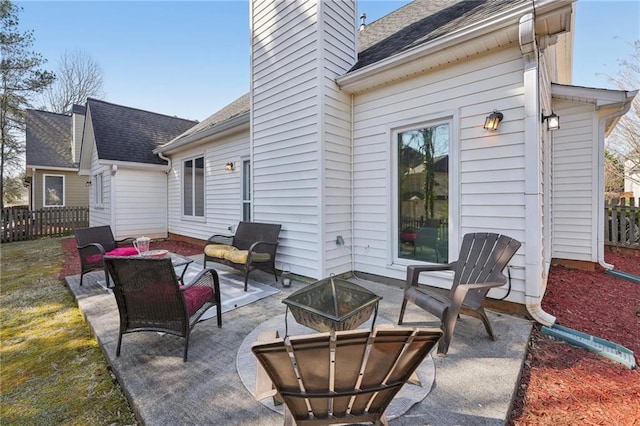 view of patio featuring an outdoor living space with a fire pit and fence