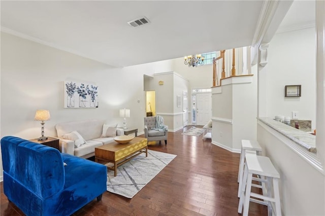 living area with visible vents, a notable chandelier, ornamental molding, dark wood finished floors, and baseboards