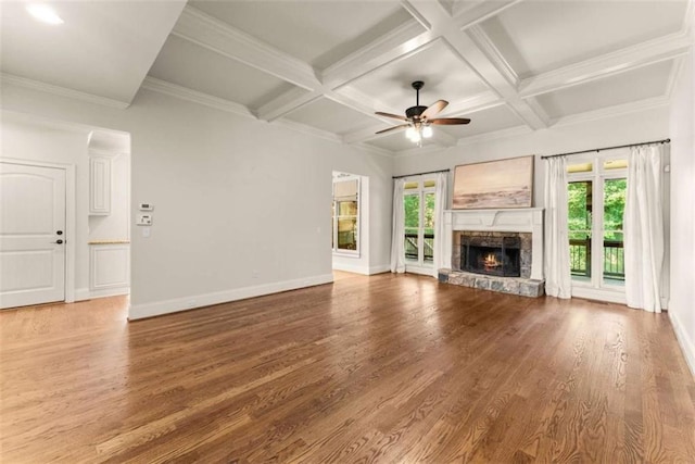 2539 Sagebrush Trl, Buford, GA 30519 - unfurnished living room featuring healthy amount of natural light, ceiling fan, a stone fireplace, wood finished floors, and coffered ceiling