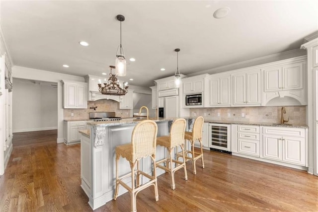2539 Sagebrush Trl, Buford, GA 30519 - kitchen featuring wine cooler, built in appliances, decorative backsplash, recessed lighting, and wood finished floors