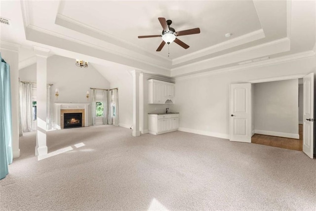 2539 Sagebrush Trl, Buford, GA 30519 - unfurnished living room with a tray ceiling, a ceiling fan, light colored carpet, a warm lit fireplace, and ornamental molding