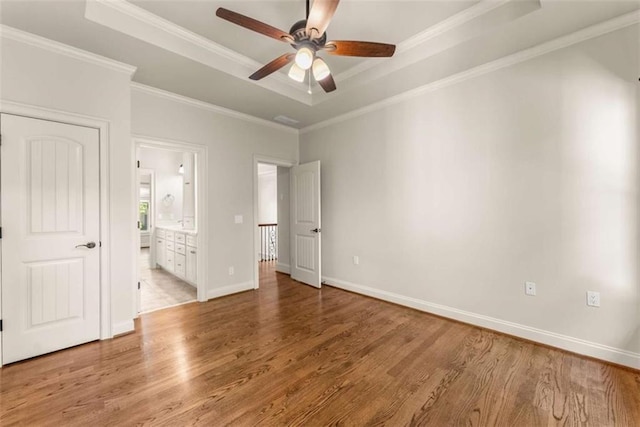 2539 Sagebrush Trl, Buford, GA 30519 - unfurnished bedroom with light wood-style flooring, a raised ceiling, ornamental molding, ensuite bath, and a ceiling fan
