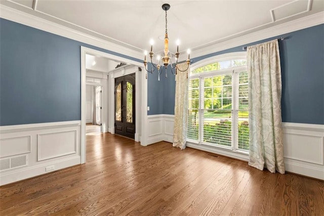 2539 Sagebrush Trl, Buford, GA 30519 - unfurnished dining area with a chandelier, wainscoting, crown molding, a decorative wall, and wood finished floors