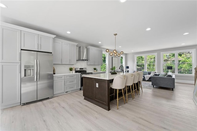 101 Fairfield Ct, Atlanta, GA 30314 - kitchen featuring stainless steel appliances, wall chimney exhaust hood, light wood-type flooring, recessed lighting, and an island with sink