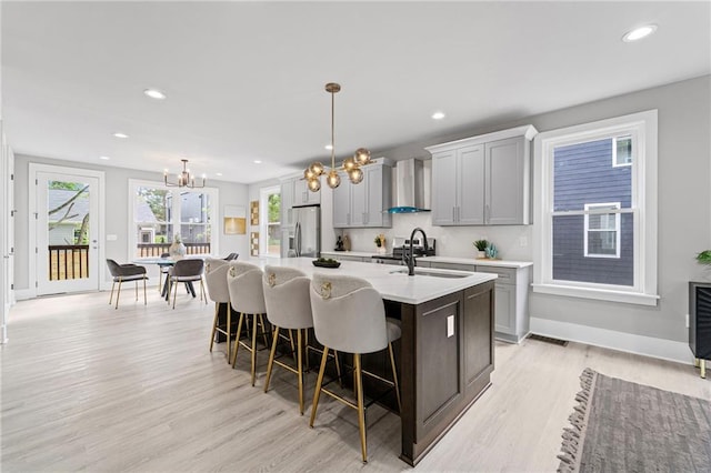 101 Fairfield Ct, Atlanta, GA 30314 - kitchen with stainless steel refrigerator with ice dispenser, wall chimney exhaust hood, a sink, a chandelier, and an island with sink