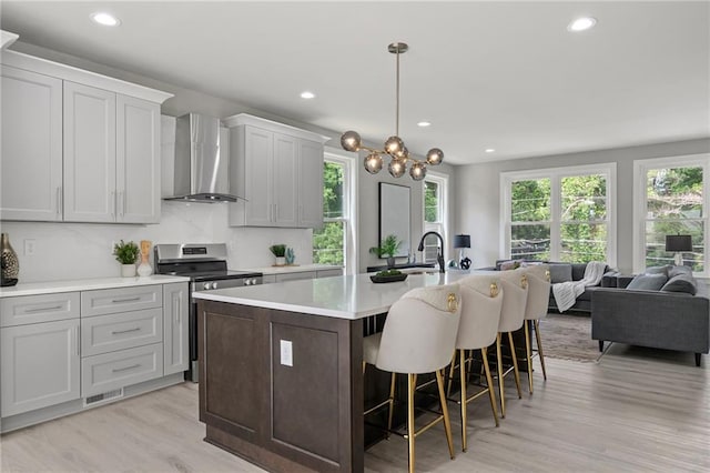101 Fairfield Ct, Atlanta, GA 30314 - kitchen with wall chimney exhaust hood, electric range, recessed lighting, light wood-style floors, and a center island with sink