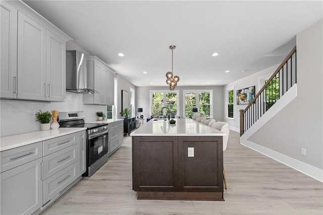 101 Fairfield Ct, Atlanta, GA 30314 - kitchen featuring stainless steel electric range, wall chimney range hood, recessed lighting, light countertops, and an island with sink