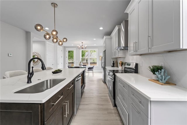 101 Fairfield Ct, Atlanta, GA 30314 - kitchen featuring stainless steel appliances, a sink, an island with sink, a chandelier, and light wood-style flooring