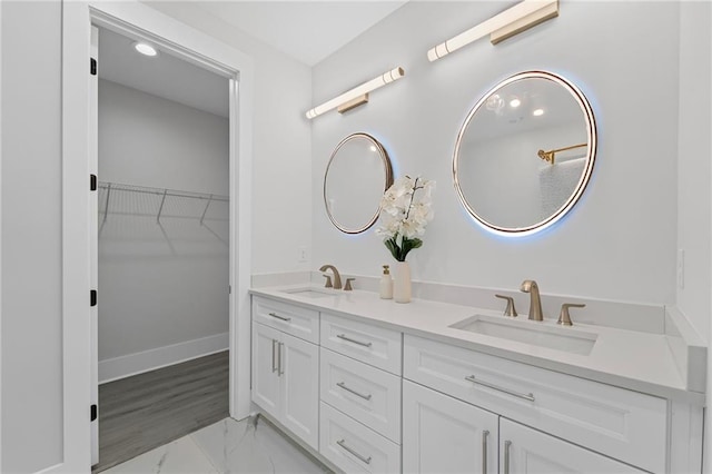 101 Fairfield Ct, Atlanta, GA 30314 - bathroom featuring double vanity, a spacious closet, marble look tile flooring, and baseboards