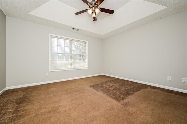 unfurnished room featuring baseboards, a raised ceiling, visible vents, and dark carpet