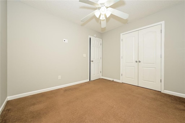 unfurnished bedroom with carpet, baseboards, and a textured ceiling