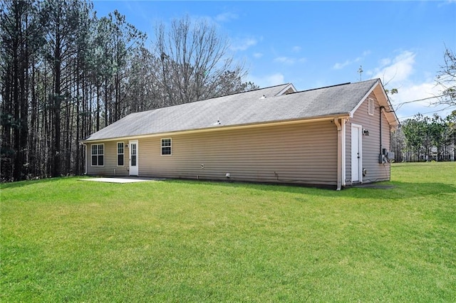 rear view of house featuring a patio area and a lawn