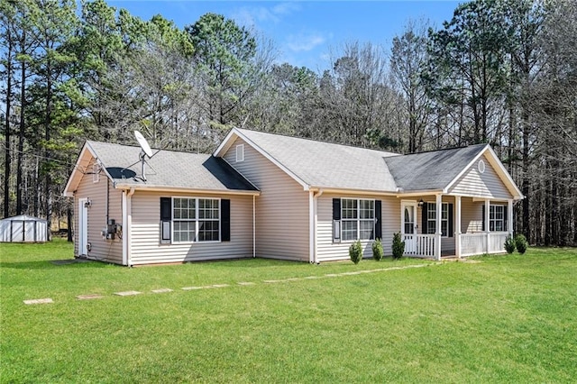 ranch-style house with an outbuilding, covered porch, a storage unit, and a front lawn