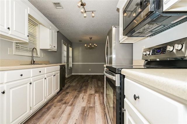 kitchen with visible vents, a sink, white cabinets, appliances with stainless steel finishes, and a textured ceiling