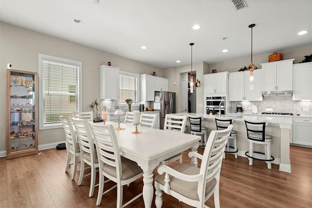 dining area with light wood-type flooring and a healthy amount of sunlight