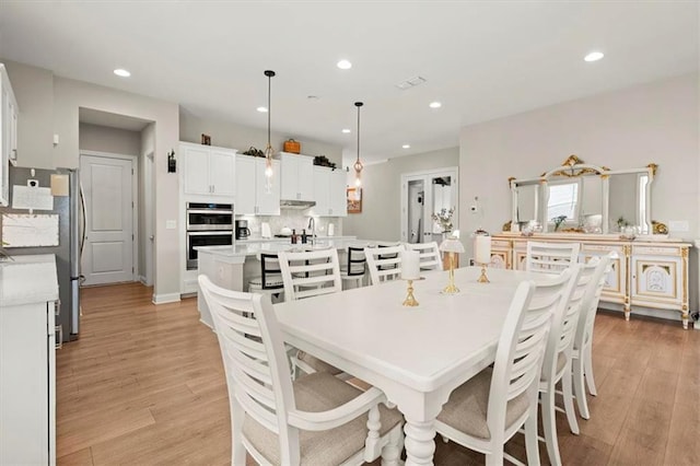 dining room with sink and light hardwood / wood-style floors