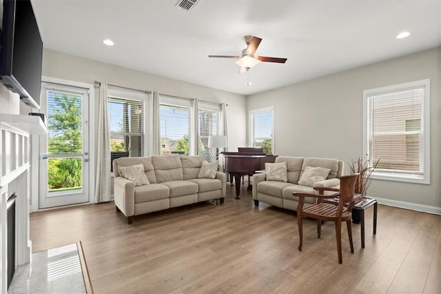 living room with light wood-type flooring and ceiling fan