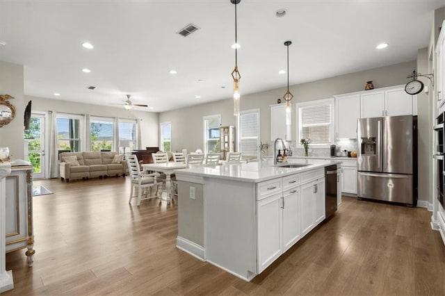 kitchen featuring a center island with sink, stainless steel appliances, hardwood / wood-style floors, and sink