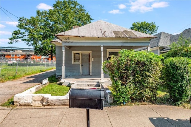 view of front of house featuring a porch and fence