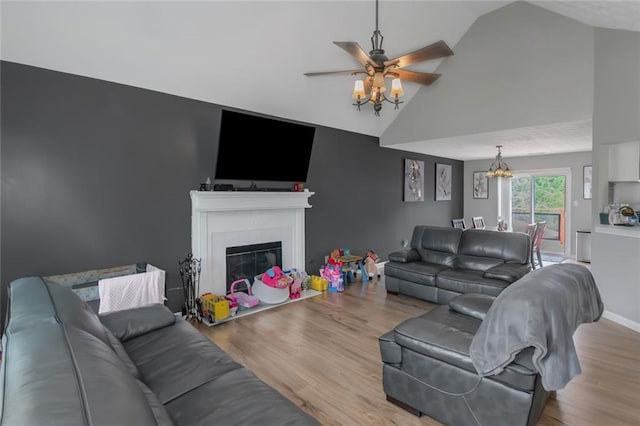 147 Midland Dr, Stockbridge, GA 30281 - living area with a ceiling fan, wood finished floors, a chandelier, a glass covered fireplace, and high vaulted ceiling