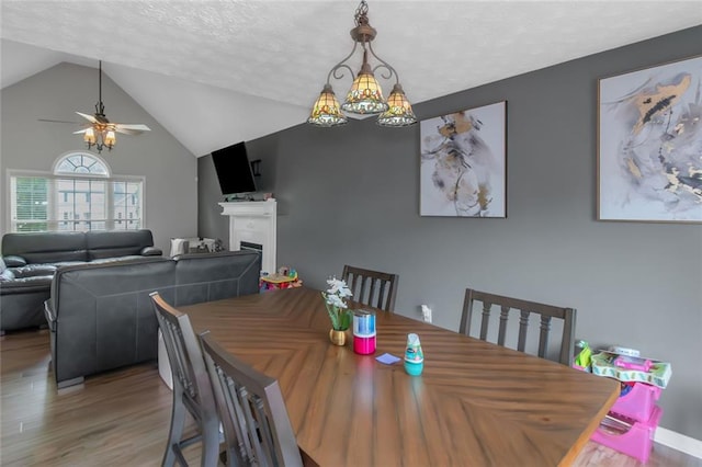 147 Midland Dr, Stockbridge, GA 30281 - dining space with wood finished floors, a ceiling fan, lofted ceiling, a fireplace, and a textured ceiling