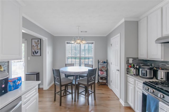 147 Midland Dr, Stockbridge, GA 30281 - dining area featuring a chandelier, light wood-type flooring, baseboards, and crown molding