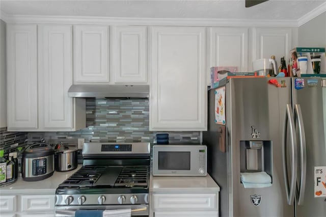 147 Midland Dr, Stockbridge, GA 30281 - kitchen with appliances with stainless steel finishes, under cabinet range hood, white cabinets, and crown molding