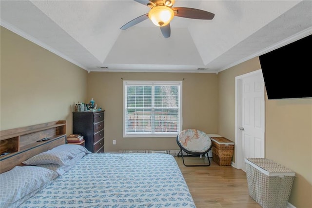 147 Midland Dr, Stockbridge, GA 30281 - bedroom with light wood finished floors, a tray ceiling, a ceiling fan, and ornamental molding