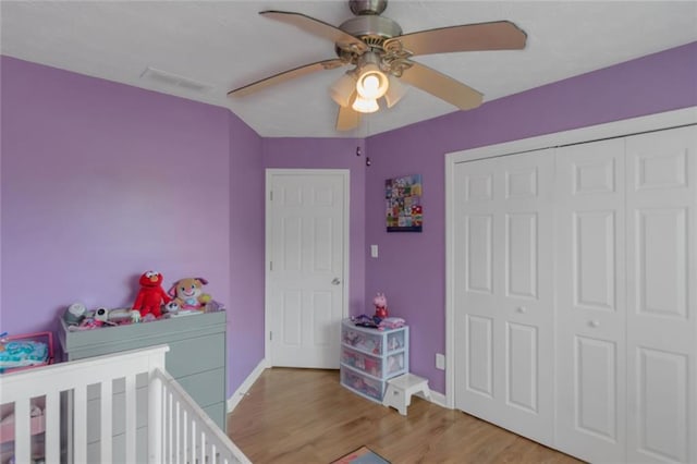 147 Midland Dr, Stockbridge, GA 30281 - bedroom with baseboards, light wood-style floors, a closet, a crib, and a ceiling fan