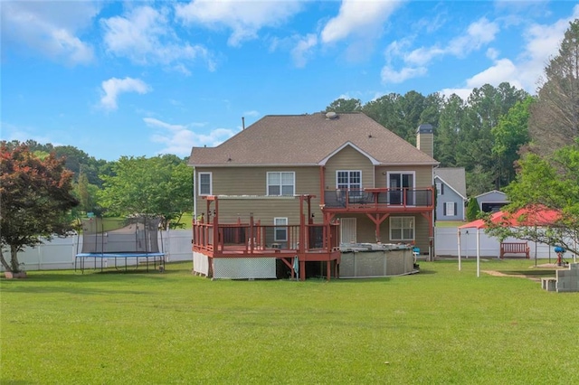 147 Midland Dr, Stockbridge, GA 30281 - back of property with a trampoline, a wooden deck, a chimney, and an outdoor pool