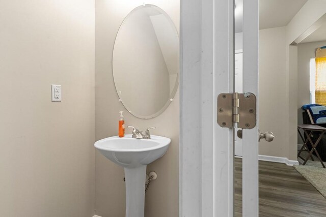 bathroom with a sink, baseboards, and wood finished floors