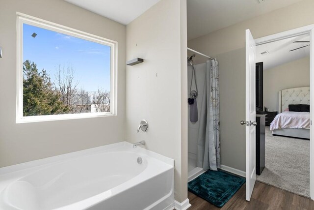 ensuite bathroom with a bath, connected bathroom, a shower stall, and wood finished floors