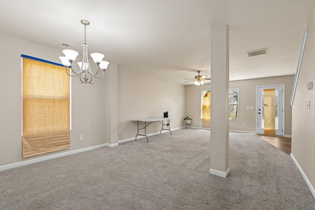 unfurnished living room with visible vents, baseboards, carpet flooring, and ceiling fan with notable chandelier