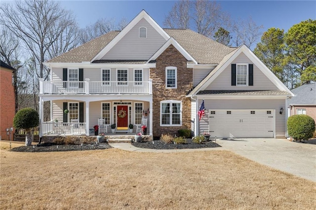 view of front of home with a shingled roof, concrete driveway, a balcony, a porch, and a front yard