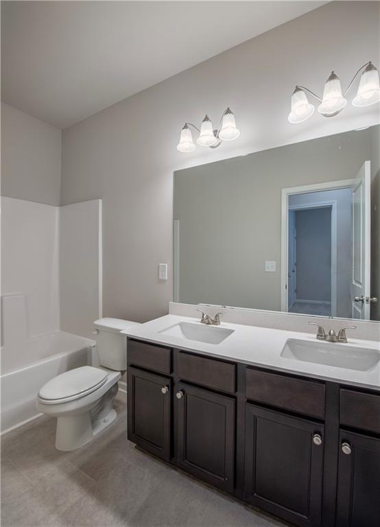 full bathroom featuring vanity, shower / bath combination, and toilet