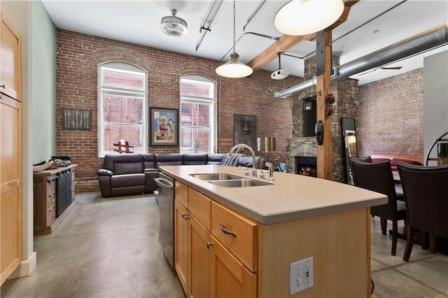 kitchen with brick wall, concrete floors, open floor plan, and a sink