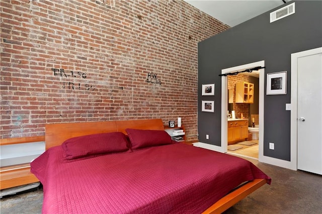 bedroom featuring brick wall, a towering ceiling, visible vents, baseboards, and ensuite bath