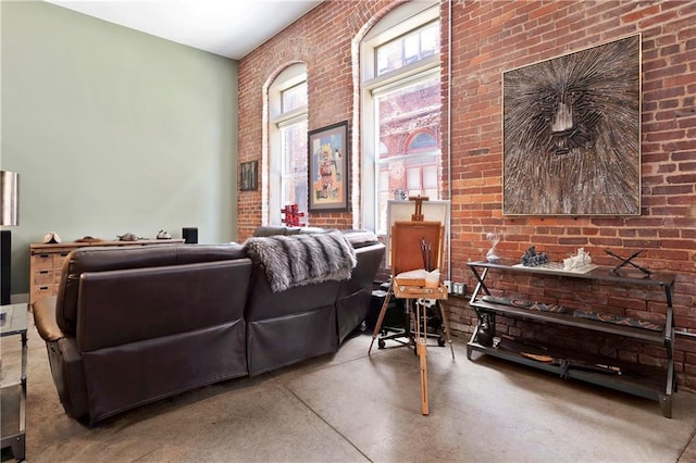 living room featuring finished concrete floors and brick wall