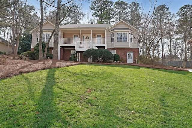 view of front facade featuring a front lawn, brick siding, and covered porch