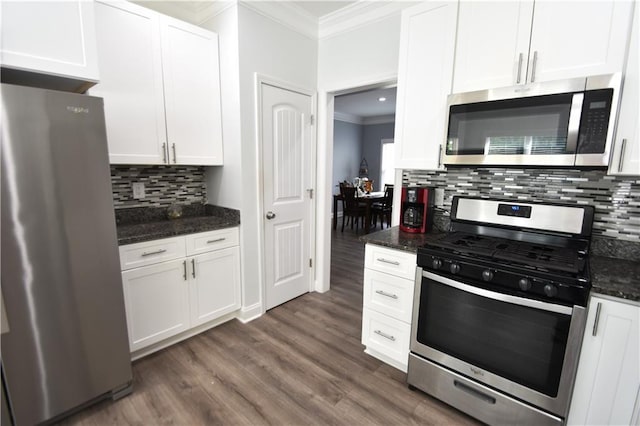 kitchen with white cabinetry, appliances with stainless steel finishes, and dark stone counters