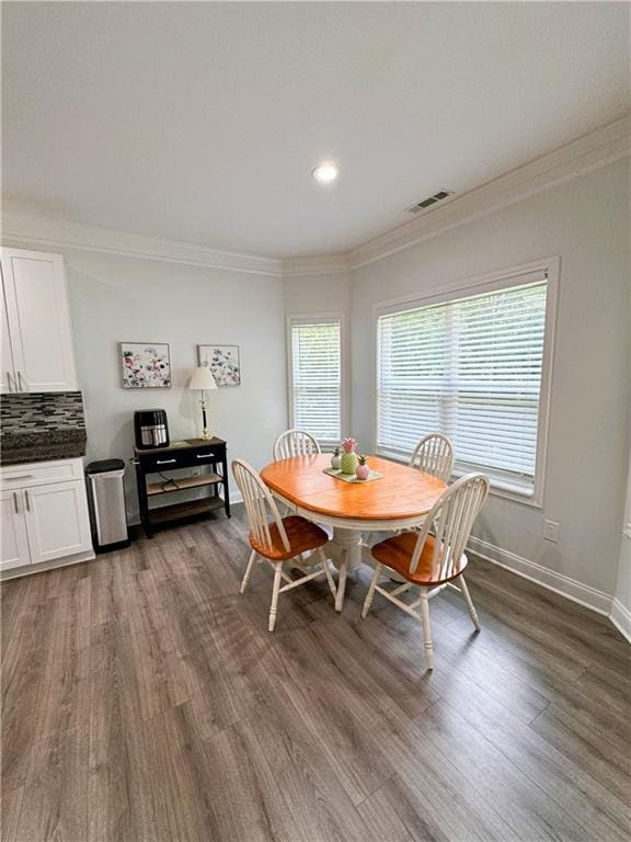 dining room featuring dark hardwood / wood-style flooring and crown molding