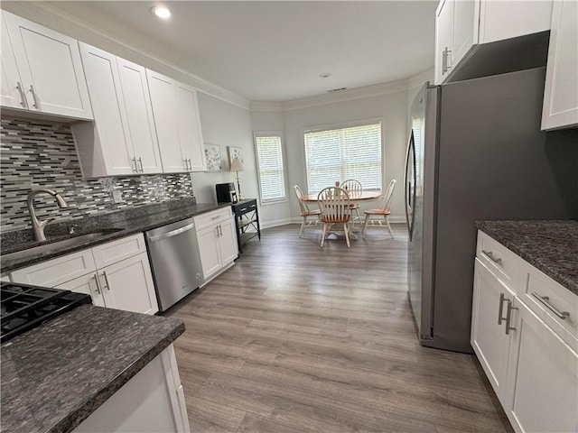 kitchen with white cabinets, appliances with stainless steel finishes, and dark stone countertops