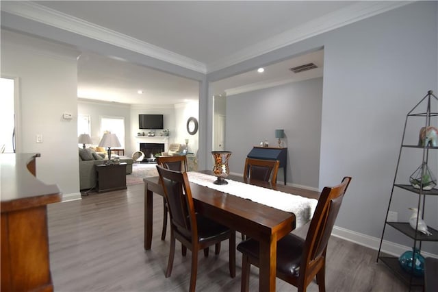 dining area with hardwood / wood-style floors and ornamental molding